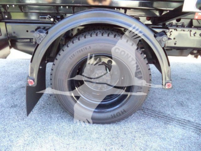 Spare tire mounted on Chevrolet Silverado 6500HD rolloff truck undercarriage with wheel and fender visible.