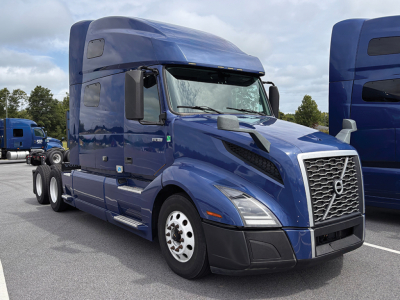 Volvo VNL 760 sleeper cab tractor in blue, side view showing front grille, mirrors, and wheels.