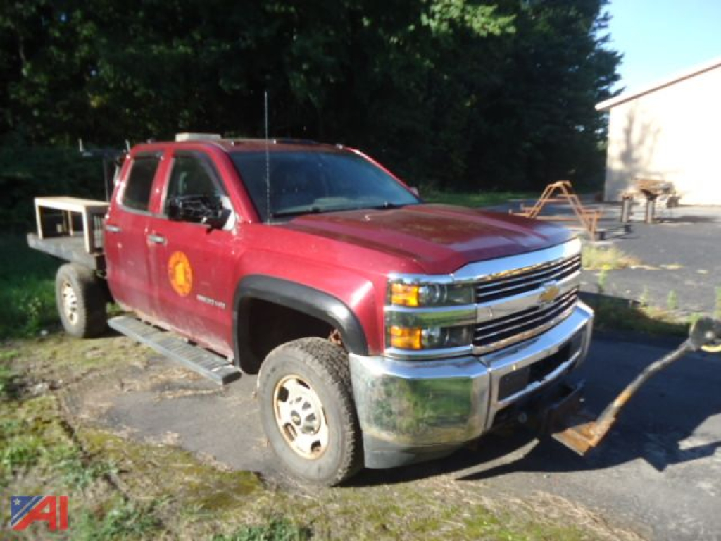 Chevrolet Silverado 2500 pickup truck in red with plow attachment and left-side view, front grille chrome, 4x4 badge obscured, worn bed area, VIN not visible.
