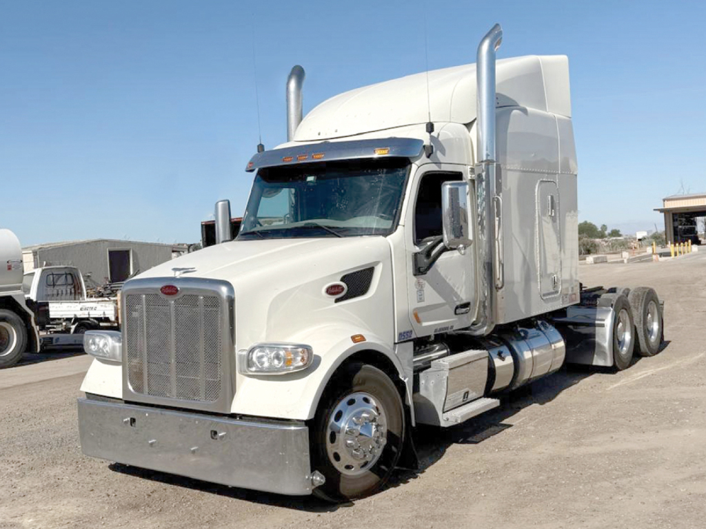 Peterbilt 567 UltraCab tractor-trailer in white, front-left view, chrome bumper, tall exhaust stacks, day cab sleeper attachment, large front grille, dual rear axles.