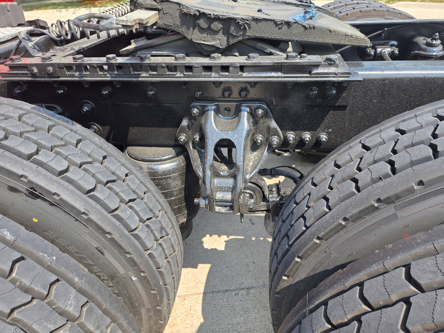 Kenworth T680 chassis and suspension showing undercarriage with dual rear axles and leaf spring, no visible fluids labels.