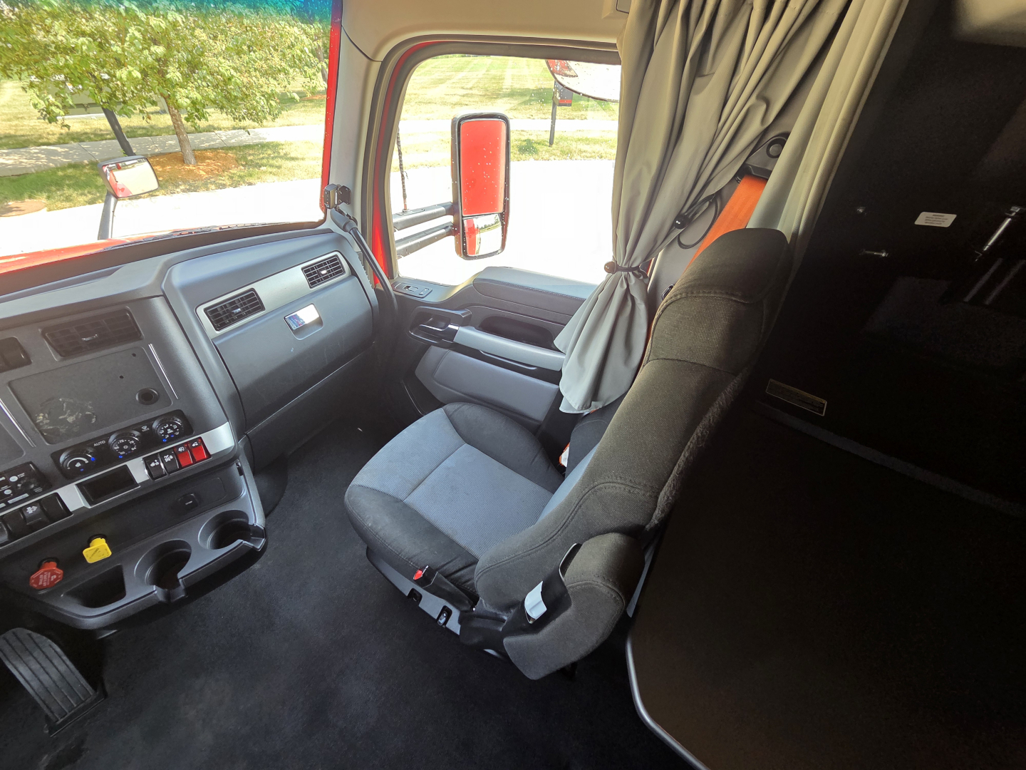 Kenworth T680 truck interior cab view showing driver seat and dashboard with steering wheel and control panel.