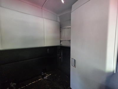 Kenworth T680 cab interior rear sleeper area with windowless side panels and storage cabinet