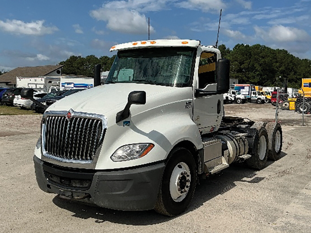 Truck cab and chassis from a white 2020 International LT625, side view showing tractor cab, front grille, and dual rear axles.