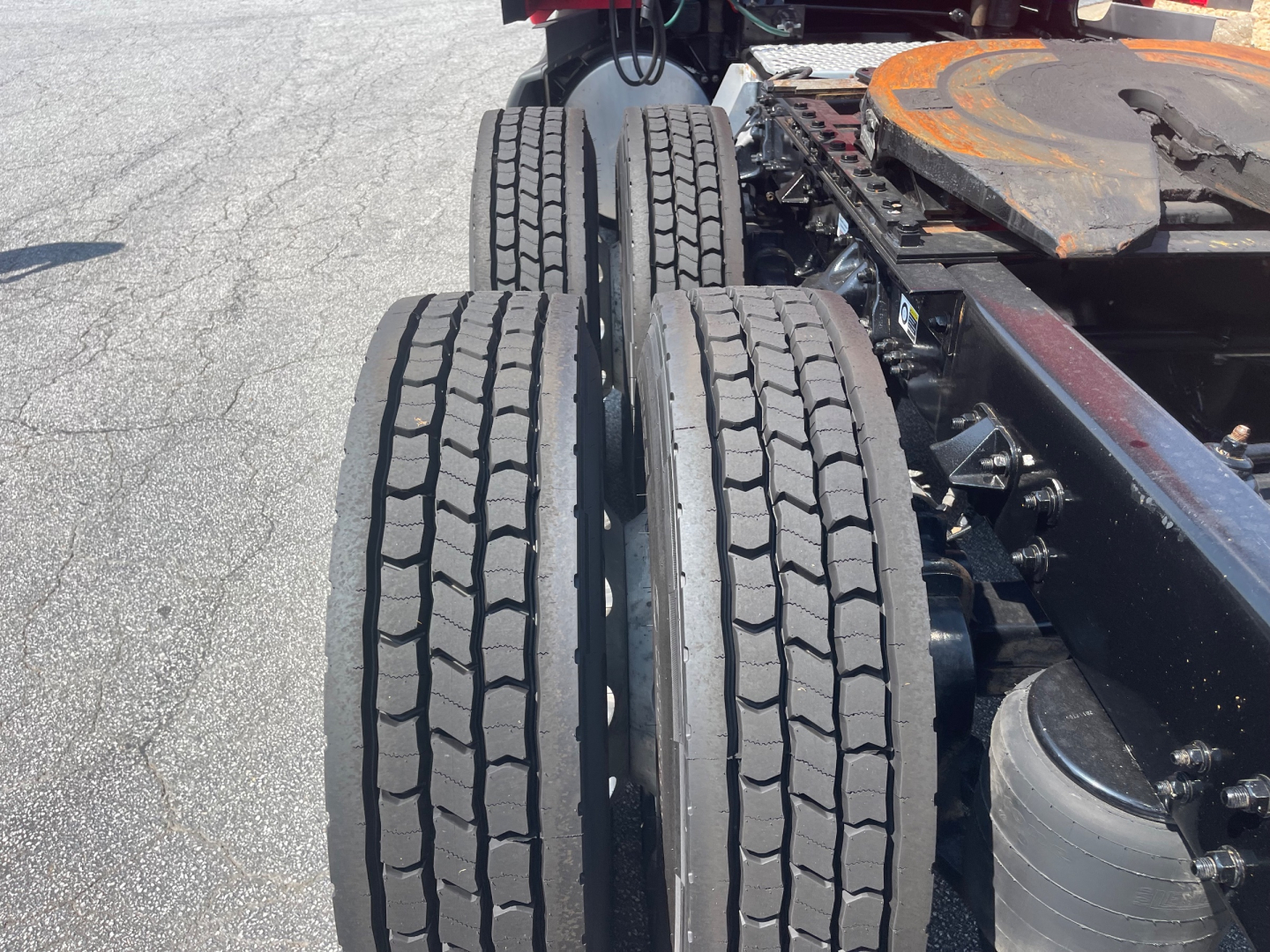 Kenworth truck chassis with dual rear axles and tires, fuel tank, and part of the frame visible.