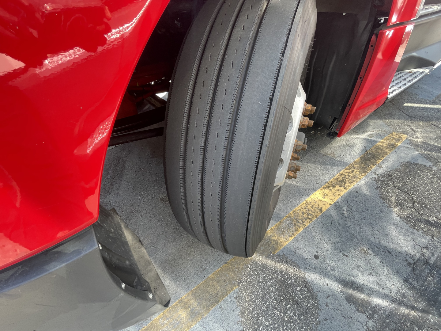 Kenworth T680 front left wheel showing tire and red cab