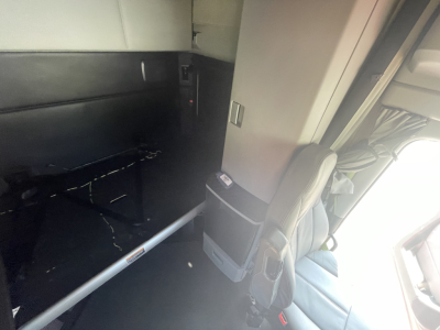 Kenworth T680 cab interior showing sleeper area and mounting bracket with door, no visible text.