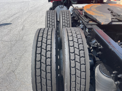 Kenworth truck chassis with dual rear axles and tires, fuel tank, and part of the frame visible.
