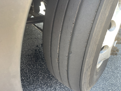 Truck tire close-up view on Kenworth T680 undercarriage.