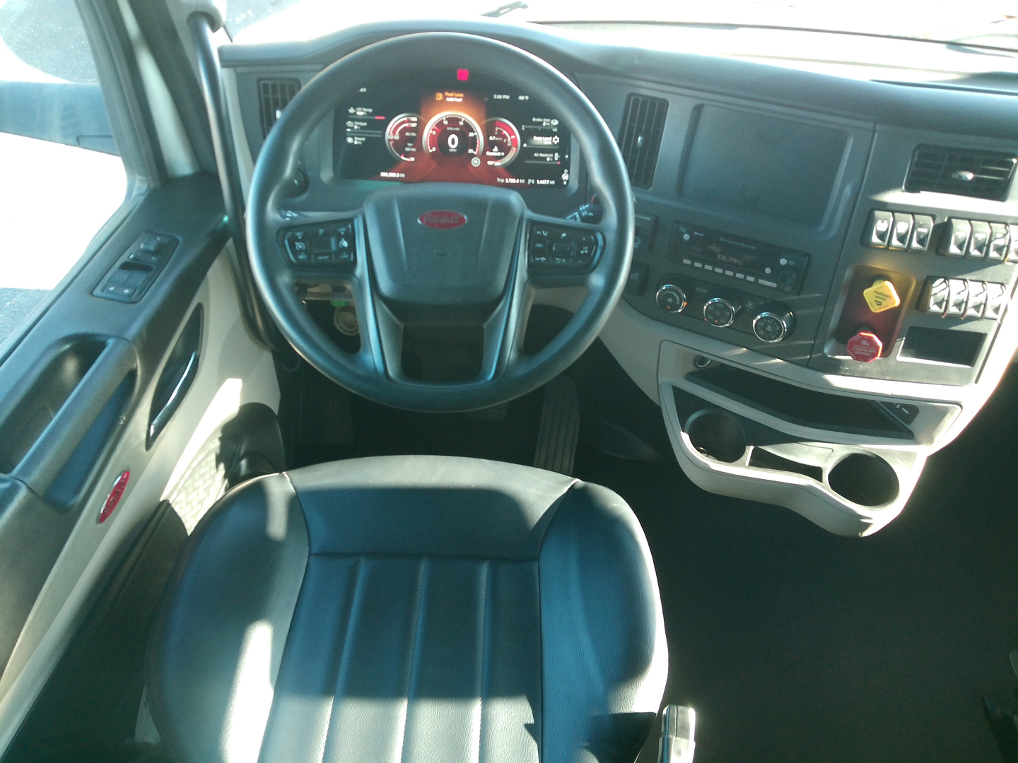 Peterbilt 579 driver cabin interior with steering wheel, dashboard, and center console visible.