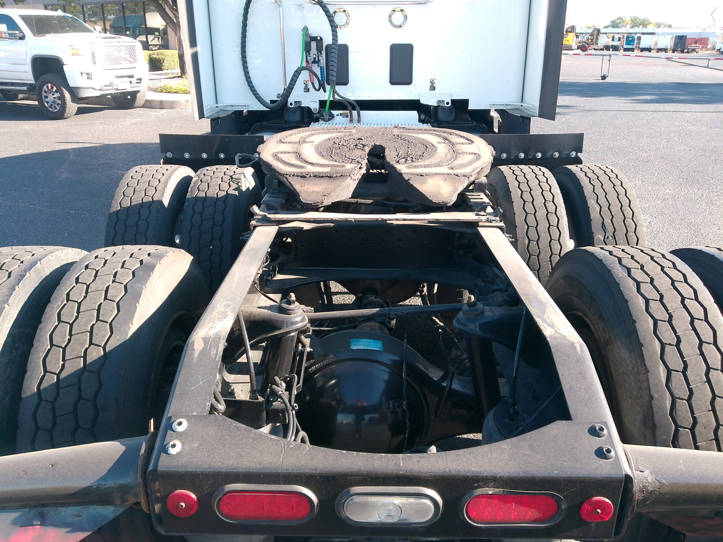 Peterbilt 579 chassis rear view showing fifth-wheel mount and dual rear axles with dual tires and driveshaft; visible undercab components and frame.