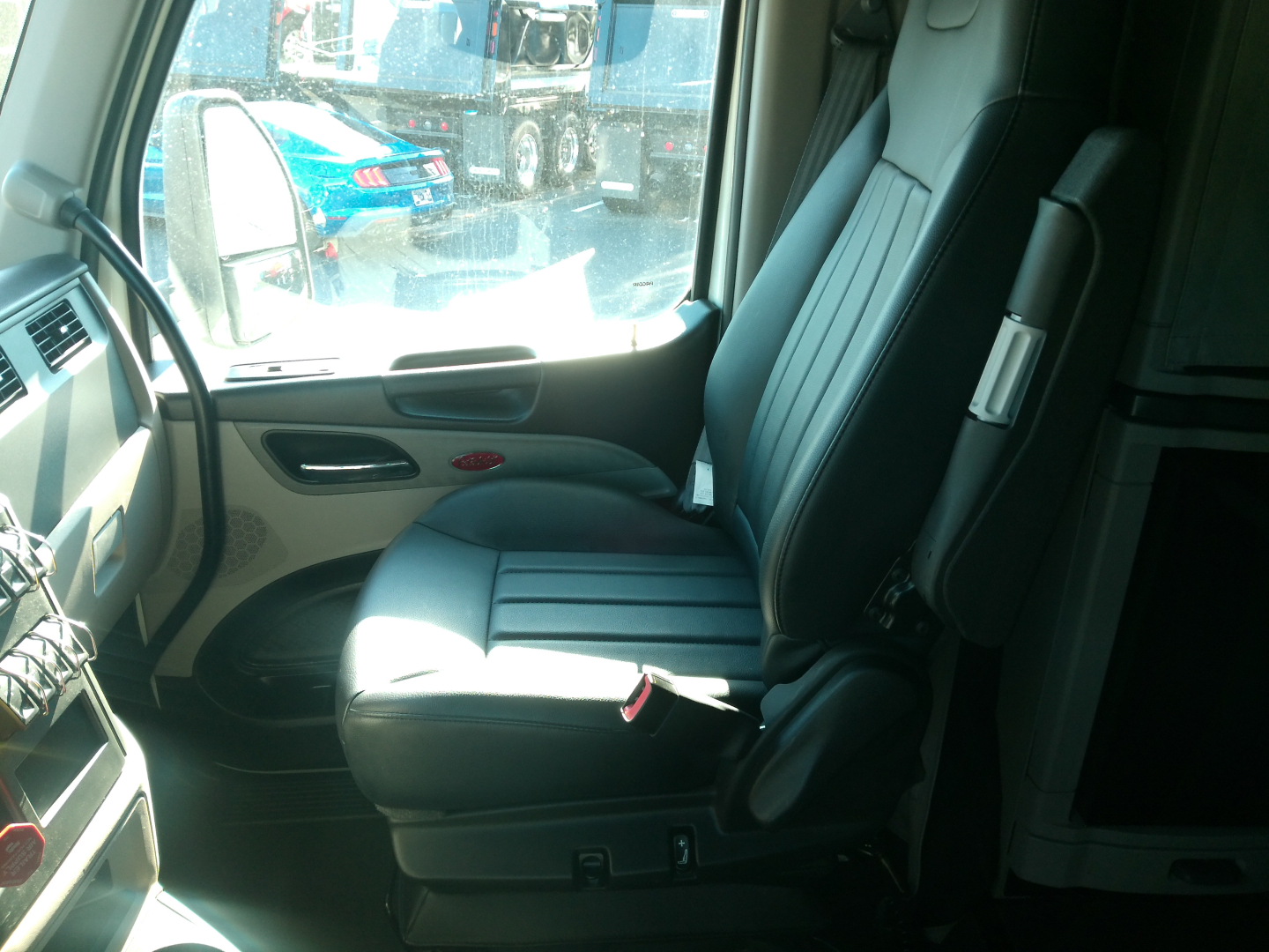 Peterbilt 579 truck interior driver seat and part of dashboard visible through open door.