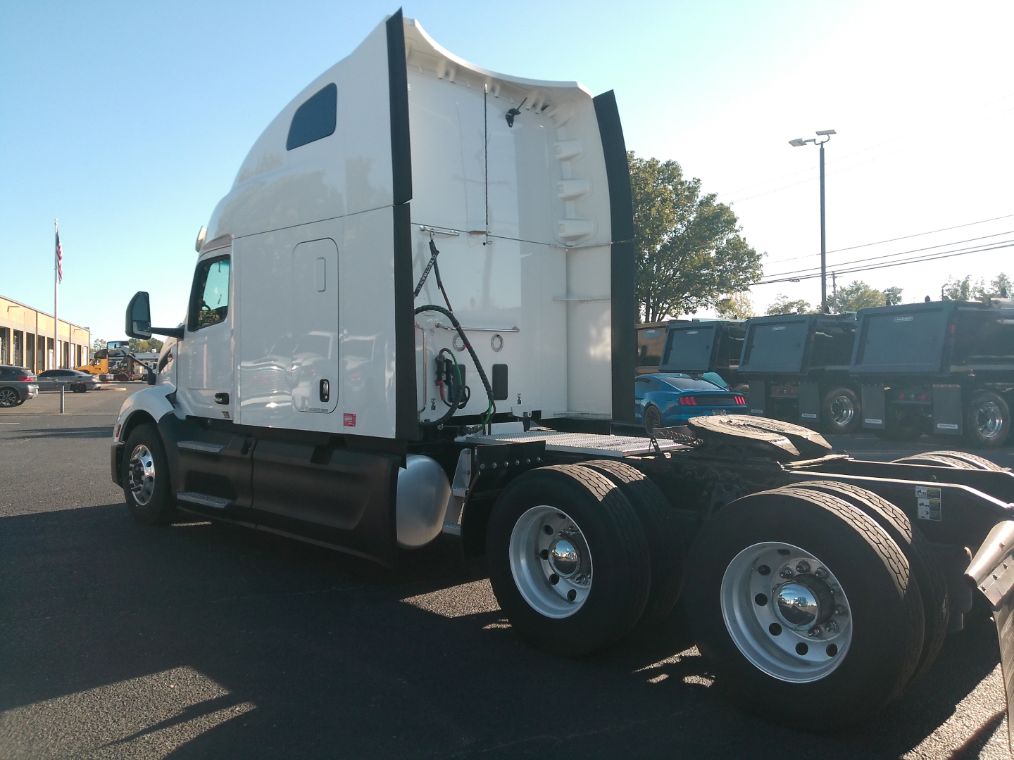Peterbilt 579 tractor side view with white cab and sleeper, dual rear axles, chassis and wheels visible, VIN 1XPBDP9X4PD863701 in listing context.