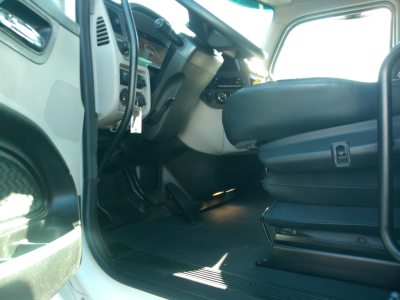 Truck cab interior of a 2023 Peterbilt 579 with open driver’s door showing steering wheel and driver's seat.
