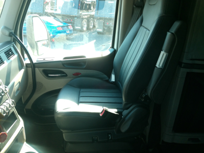 Peterbilt 579 truck interior driver seat and part of dashboard visible through open door.