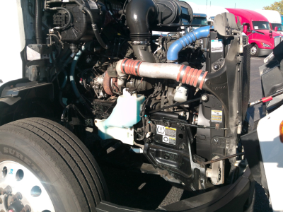 Peterbilt 579 engine bay in view showing radiator, hoses, and engine components.