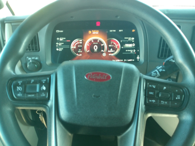 Peterbilt 579 steering wheel and dashboard view showing digital gauges and controls.