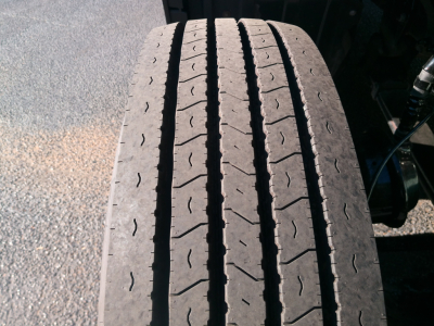 Peterbilt 579 wheel/tire tread close-up showing front axle with tread pattern and wear lines.