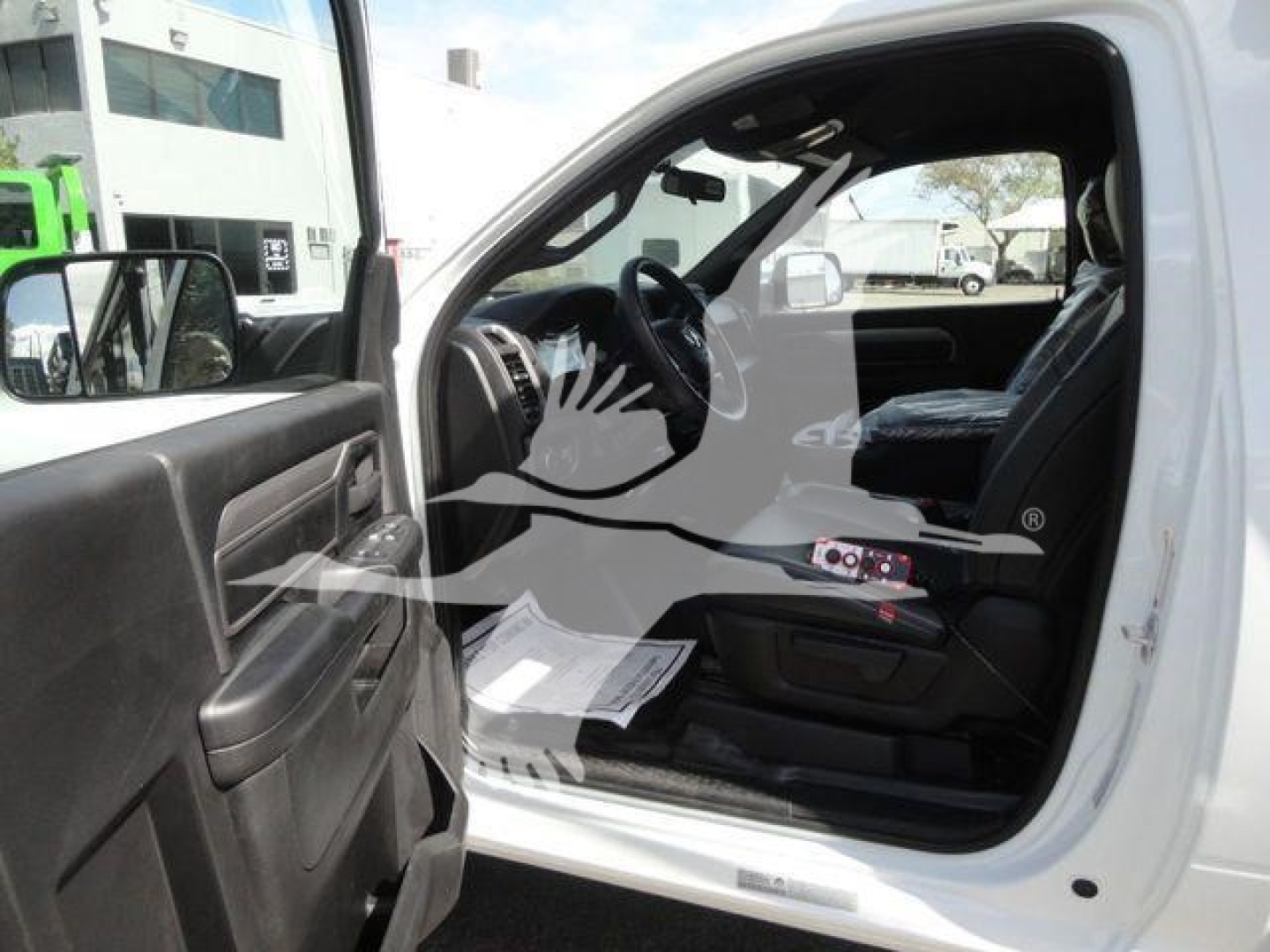 Truck cab interior view of a 2024 Ram 5500 HD from the driver’s side with open door, showing steering wheel, dashboard, and seat.