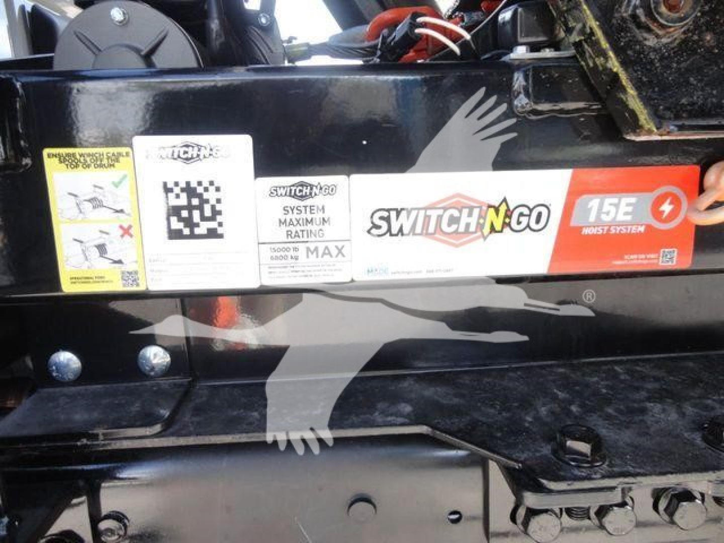 Ram 5500 HD rolloff truck equipment panel showing SWITCH-N-GO label and stickers with QR code and max rating, along with hydraulic components.