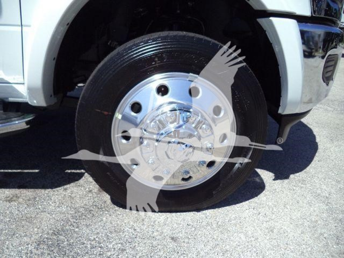 Truck wheel close-up showing polished aluminum hubcap and black tire on Ram 5500 front wheel.