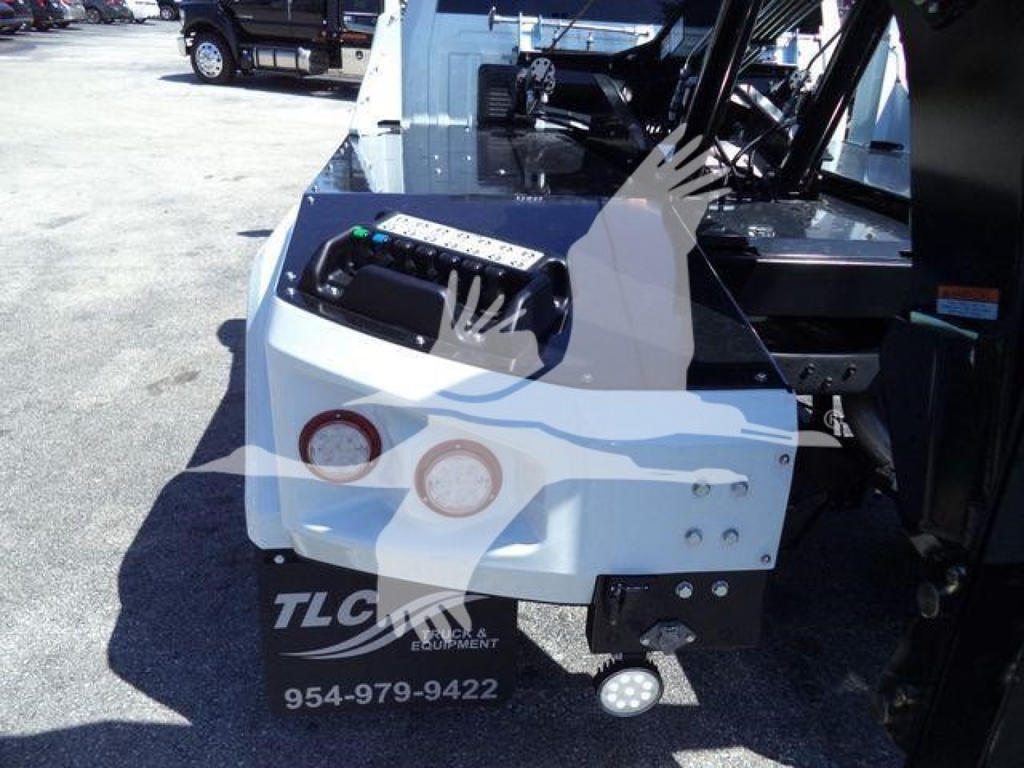 Ram 5500 winch-equipped front bumper area showing dual round headlights, white body panel, and control panel with wiring harness visible.