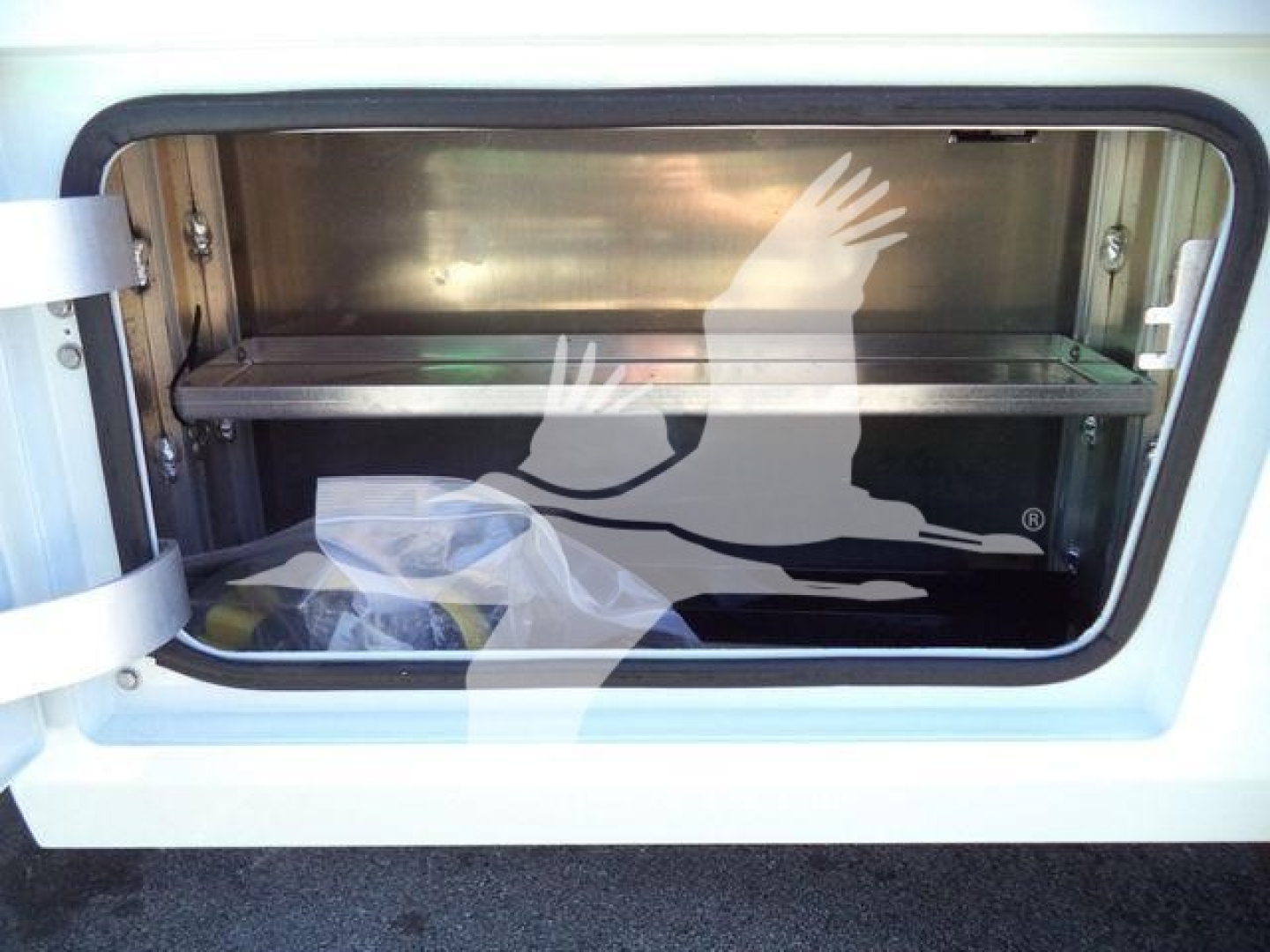 Ram 5500 winch truck bed storage with metal tub and raised barrier; no legible text visible inside unit.
