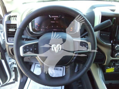 Ram steering wheel in truck interior with dashboard display visible; overlay watermark blocks some details.