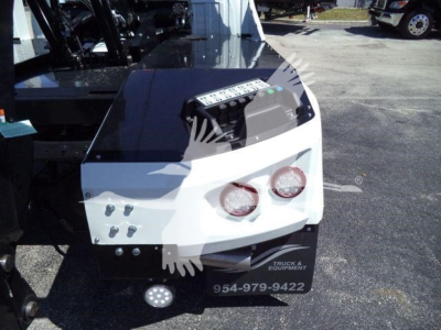 Ram 5500 winch-equipped front bumper area showing two round headlights, white and black bumper, control panel atop with various labeled buttons, and a metal winch housing.