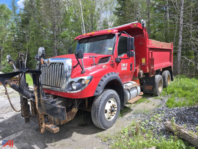Truck; 2019 International HV613 side dump in red with snowplow attachment and dump bed, front view.