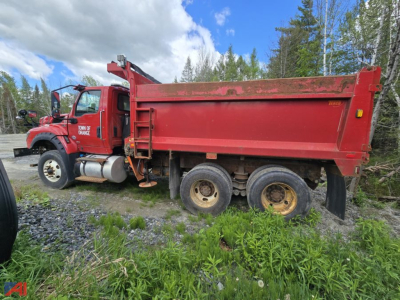 Red International HV613 dump truck side profile showing large red dumping bed and dual rear axles with mud tires.