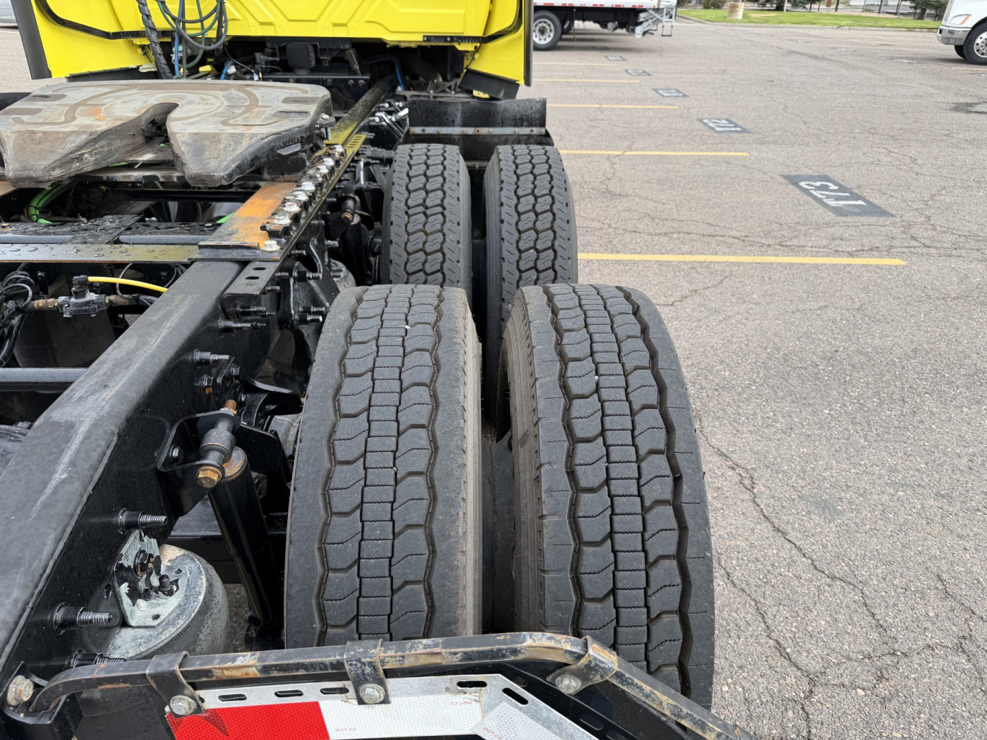 Dual rear axle and drivetrain area of a 2023 International LT625 truck showing wheel tires and chassis components.