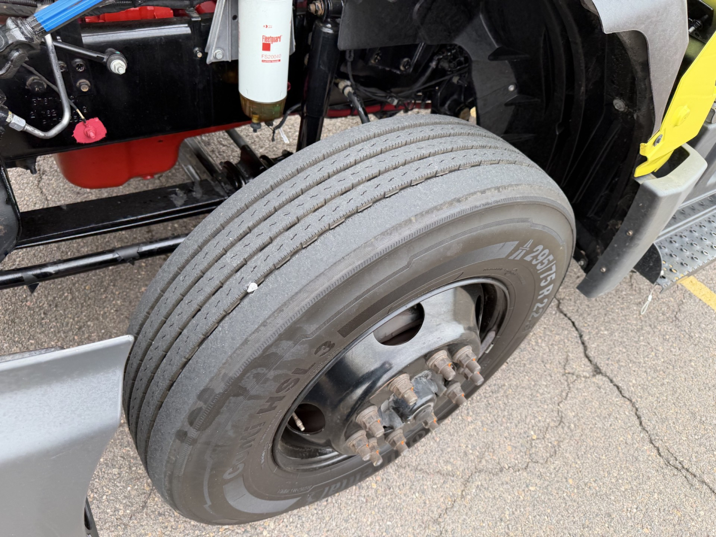 Front wheel and suspension of a 2023 International LT625 conventional daycab showing tire, hub, and part of chassis.