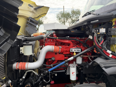 International LT Series engine bay showing red engine block with 'X15' badge and surrounding hoses, filters, and wiring.