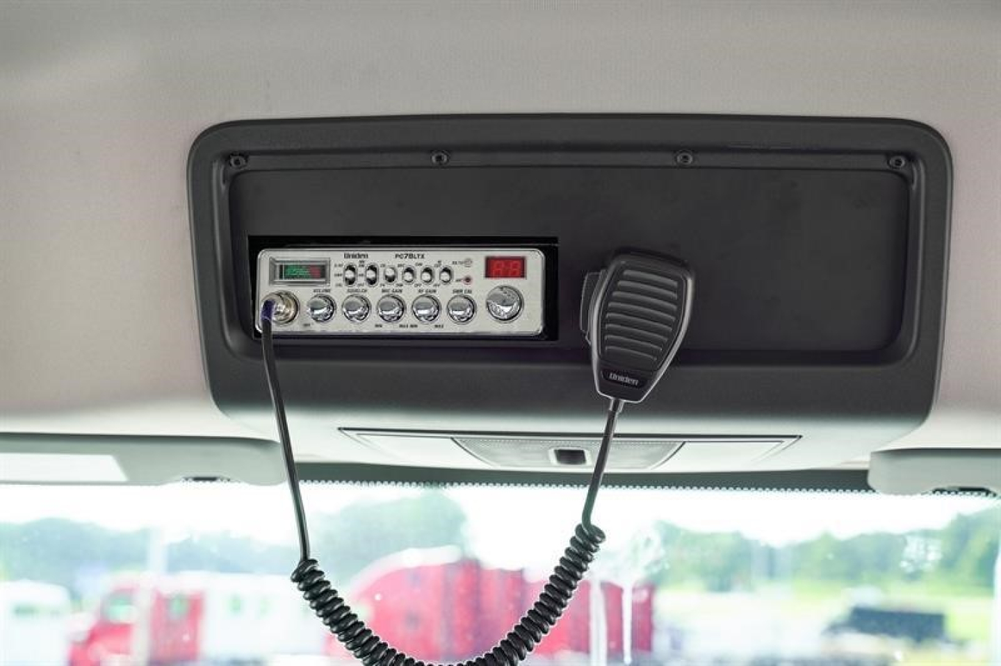 Cab and chassis truck interior showing a radio microphone and control panel mounted overhead.