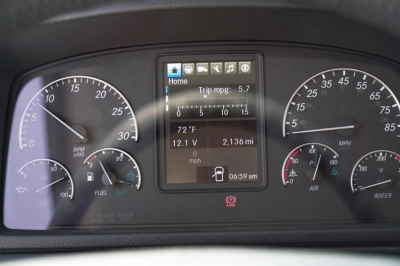Dashboard cluster and center display of a Freightliner M2 cab and chassis showing gauges, digital screen with trip mpg 5.7, 72°F, 12.1V, 2,136 mi, time 06:59 am.