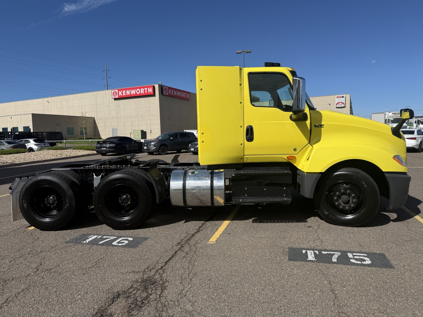 Yellow 2023 International LT625 conventional daycab truck side view showing cab and chassis with fuel tanks.