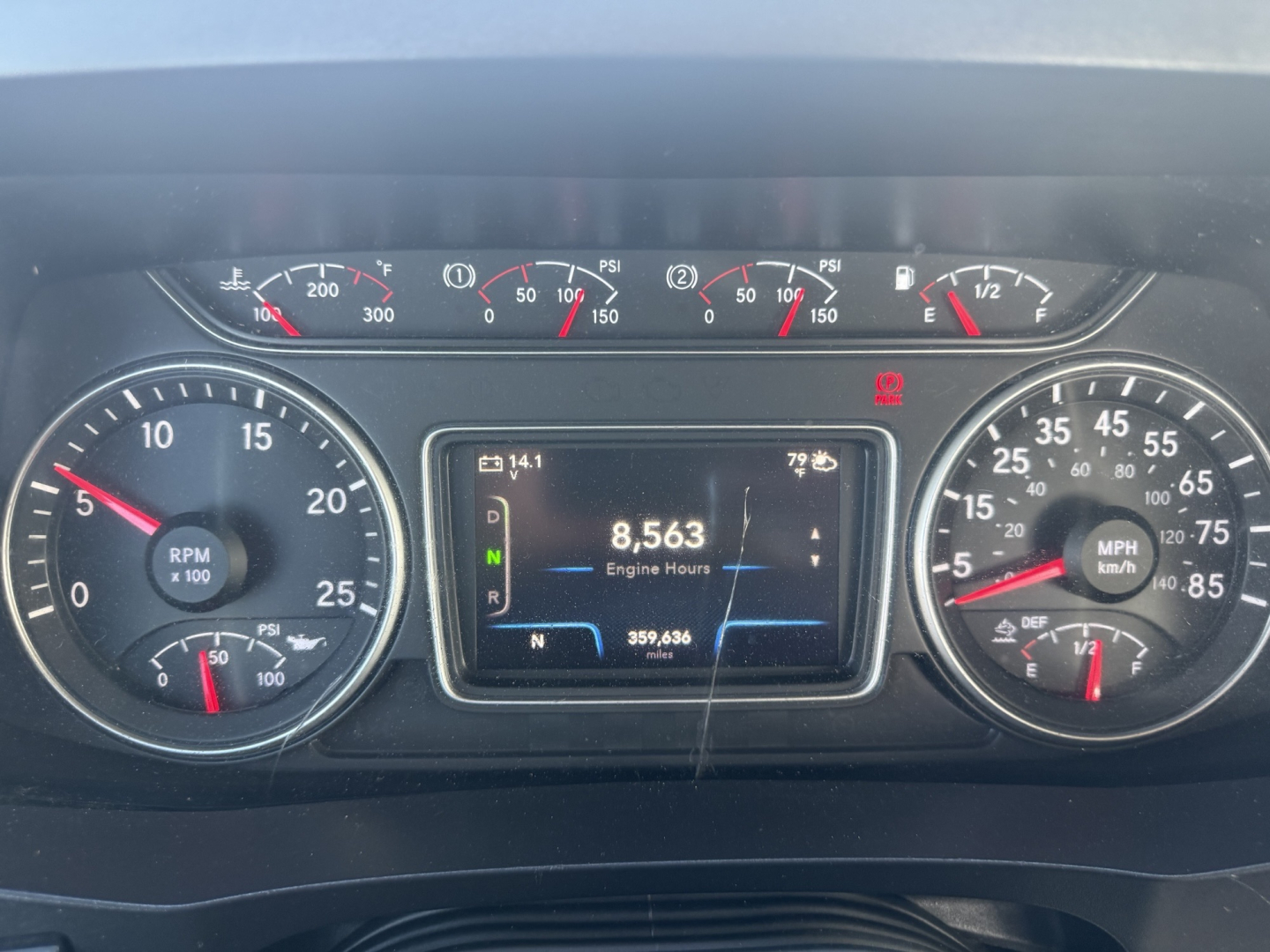 Instrumentation cluster of a 2023 International LT625 showing a digital display with 8,563 engine hours, RPM gauge, speedometer, and various gauges.