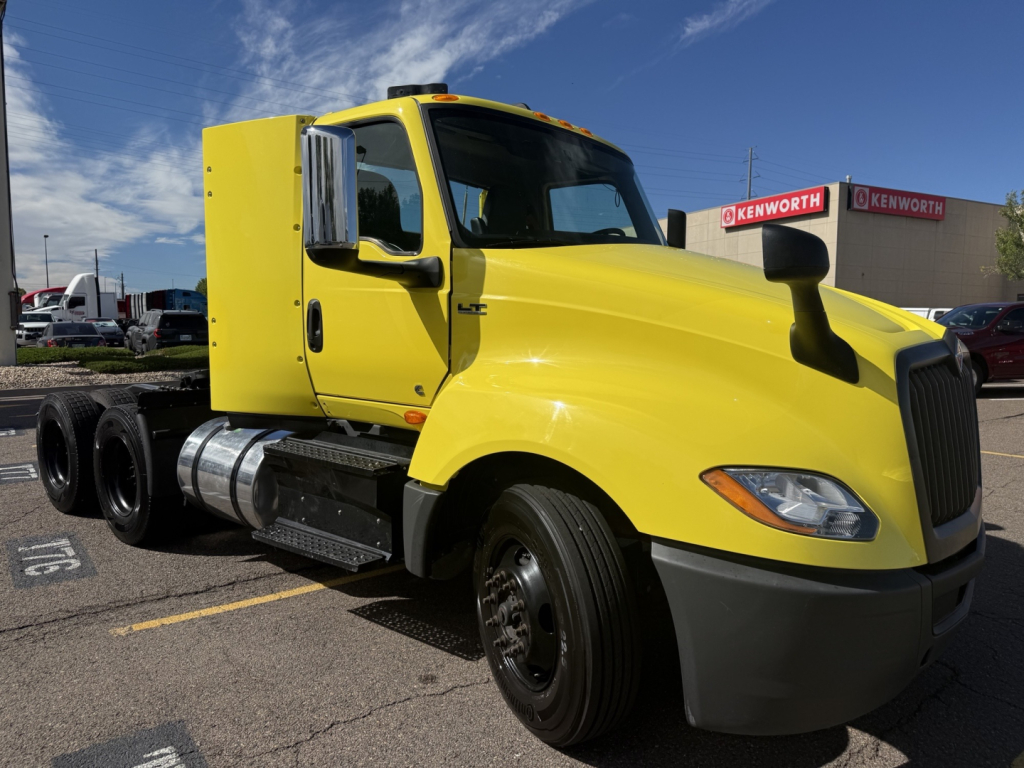 Yellow 2023 International LT625 conventional daycab truck side view showing cab, fuel tanks, and front grille.