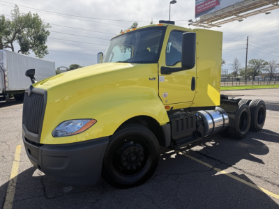 Yellow 2023 International LT625 conventional daycab tractor profile showing front driverside and cab details with 6x4 wheel configuration.
