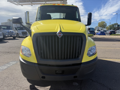 Front view of a yellow 2023 International LT625 conventional daycab truck with large black grille, black bumper, and tall side mirrors.