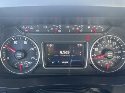 Instrumentation cluster of a 2023 International LT625 showing a digital display with 8,563 engine hours, RPM gauge, speedometer, and various gauges.