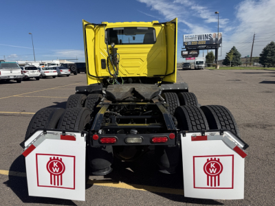 Truck rear view showing fifth wheel, dual rear axles, and white KW mud flaps with red KW logos on both sides.