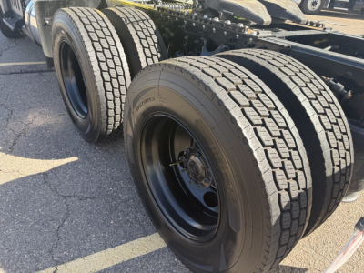 Dual rear tandem axles with large heavy-duty tires on a 2023 International LT625 truck chassis showing wheel rims and suspension components.