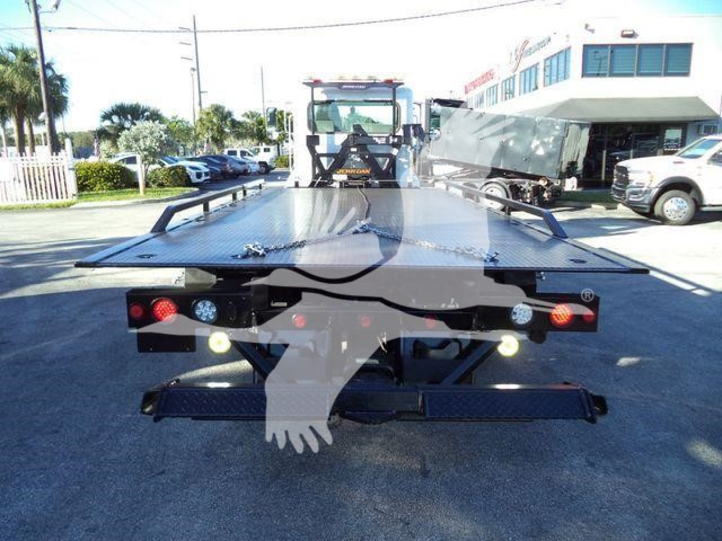 Flatbed tow truck rollback platform with rear lights and mounting hardware, viewed from the back.