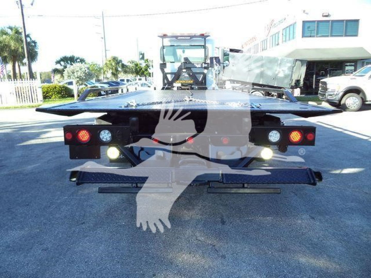 Peterbilt 337 rollback service body rear view showing taillights and hydraulic bed with platform extended.