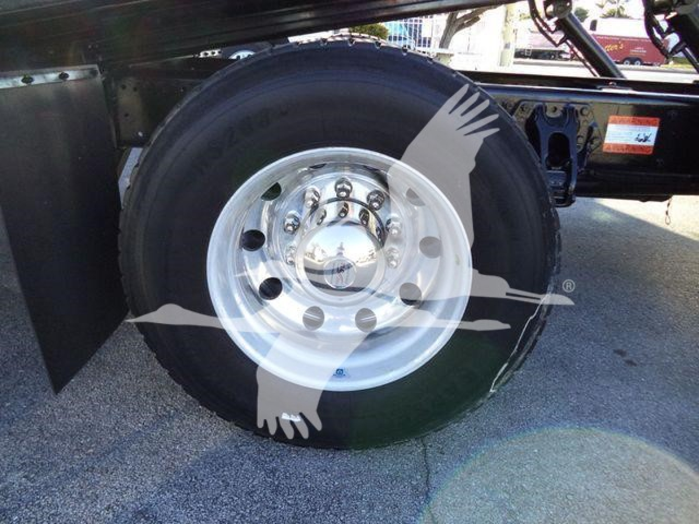 Peterbilt 337 rollback truck wheel and tire close-up showing polished steel rim and black tire.