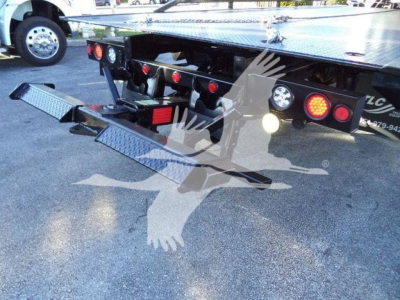 Peterbilt 337 rollback bed and rear bumper with diamond plate steps and taillights visible.