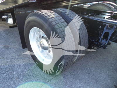 Rear-side view of a Peterbilt truck chassis showing dual rear wheels, parts of the frame, and suspension; no text readable on stickers.