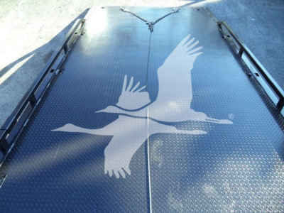 Equip­ment image showing a metal platform bed of a rollback truck with a white bird graphic. No other visible text.